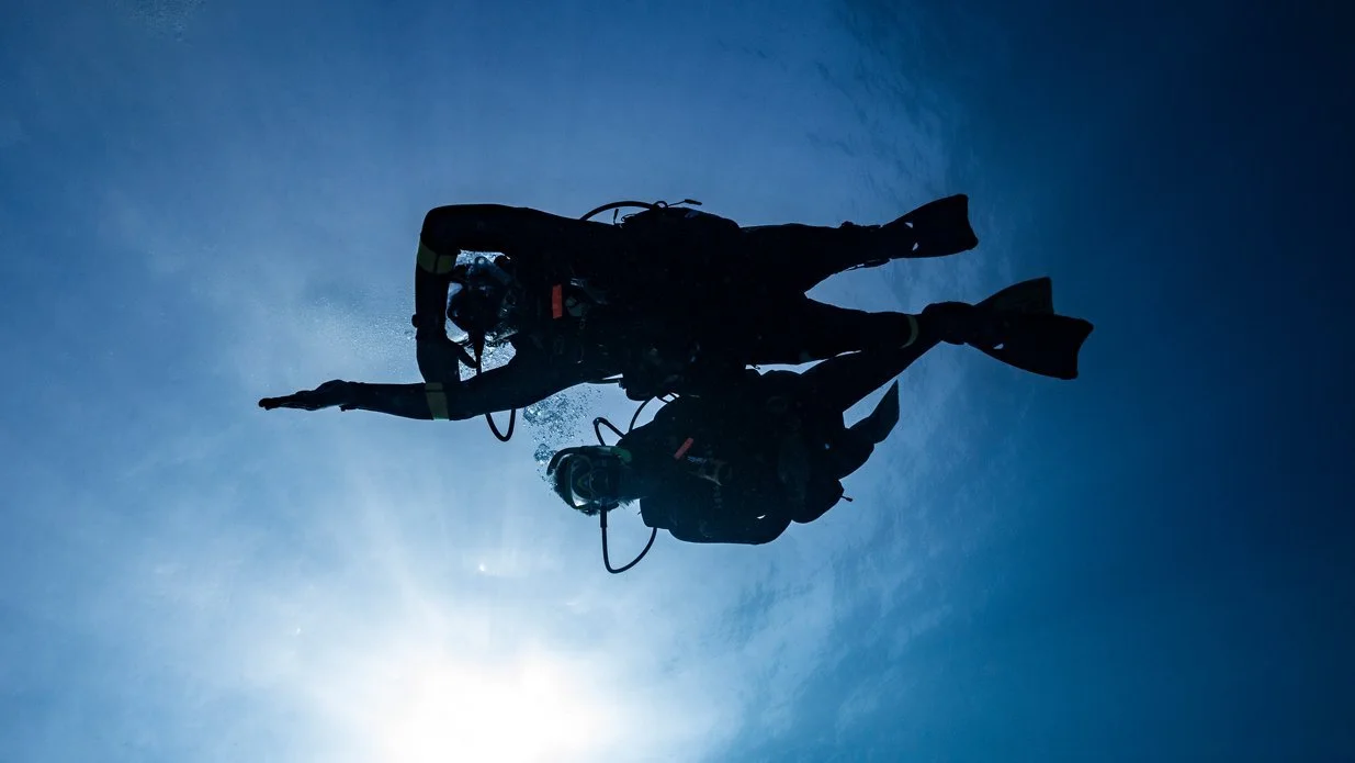 scuba divers using a compass