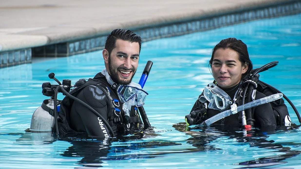 Two divers practicing in a pool