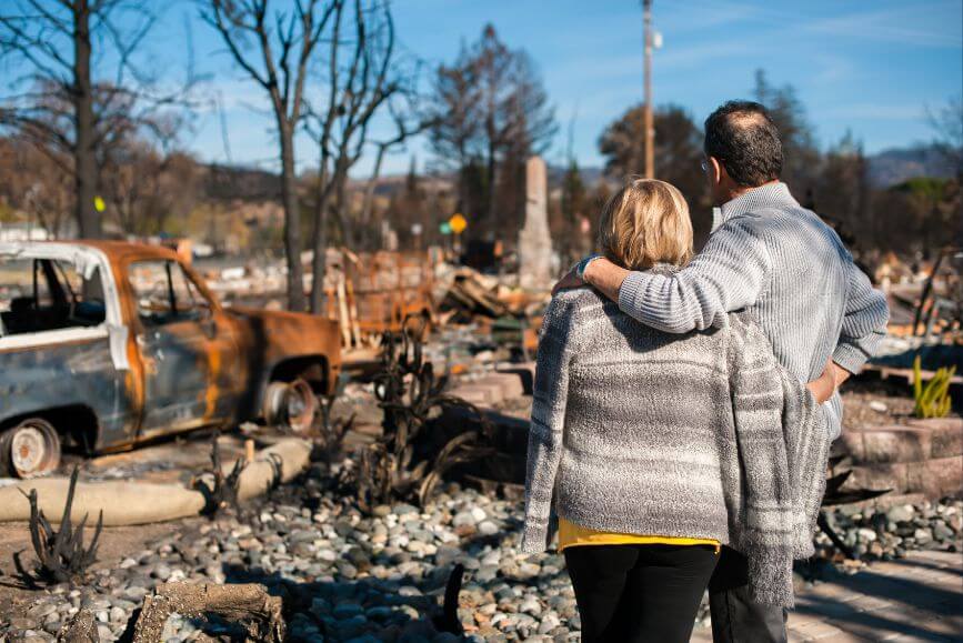 man-and-women-looking-at-burned-house.jpg