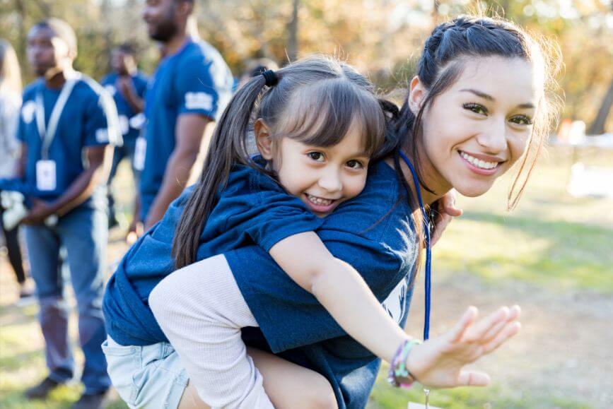 community-service-worker-carrying-little-girl.jpg