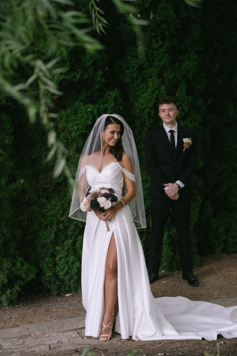 Bride and groom beneath the greenery at La Caille in Sandy, Utah