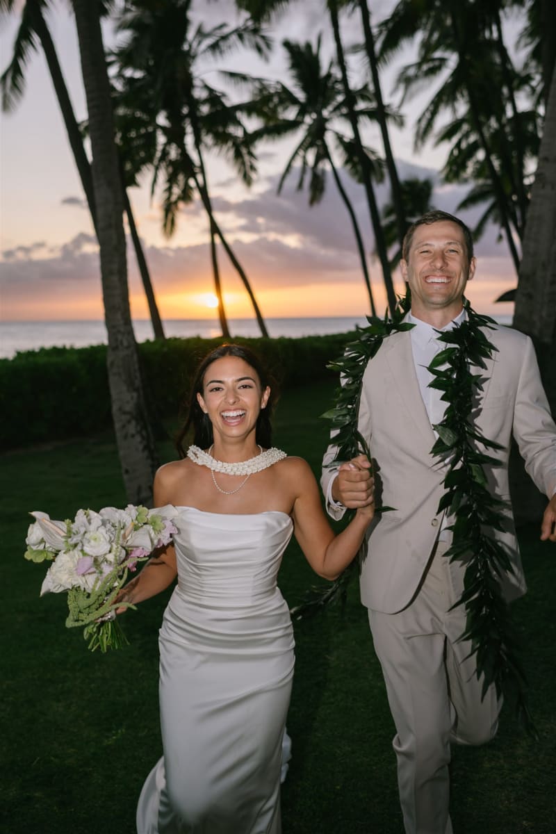 Bride and groom walking at golden hour at Lanikuhonua on Oahu