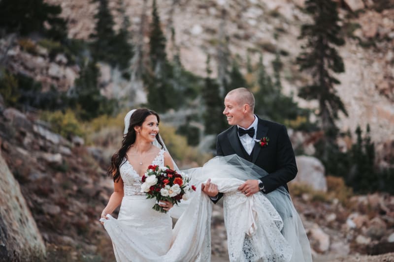 Bride and groom walking the mountainside at Snow Basin in Huntsville, Utah