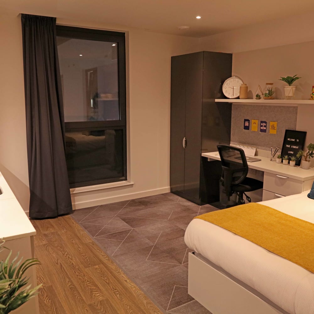 Student room with a kitchenette, desk and bed