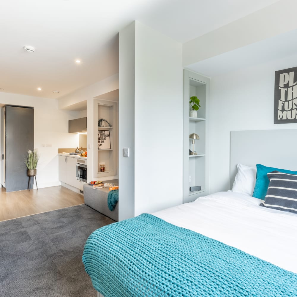 Premium student room in Salford with shelving, bed, storage and a kitchenette