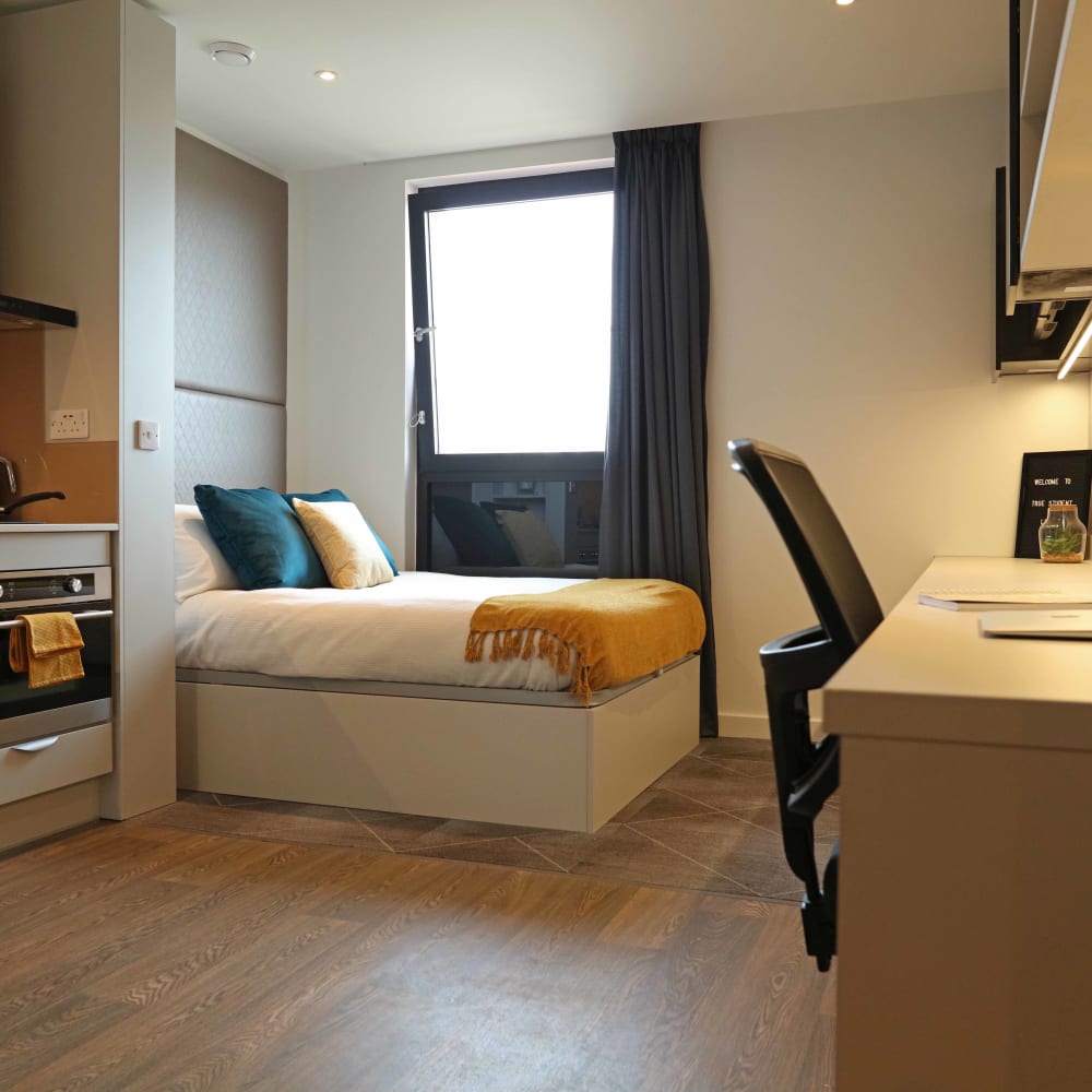 Large student room with a bed and a desk