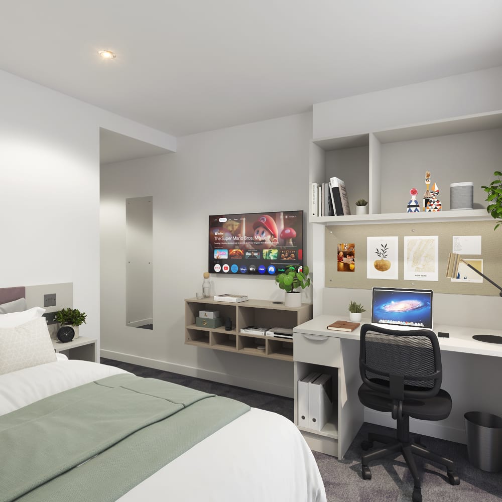 Student room with a desk area, including a bed and TV