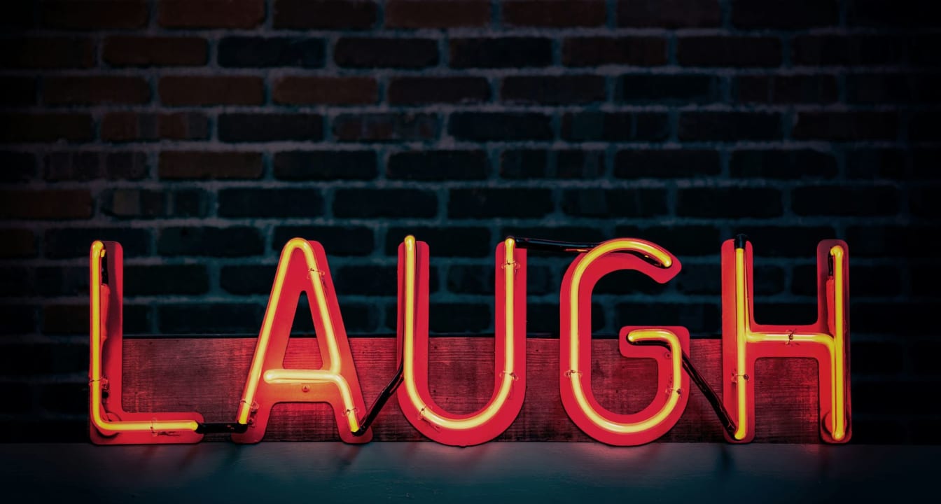 Illuminated sign that says 'Laugh'