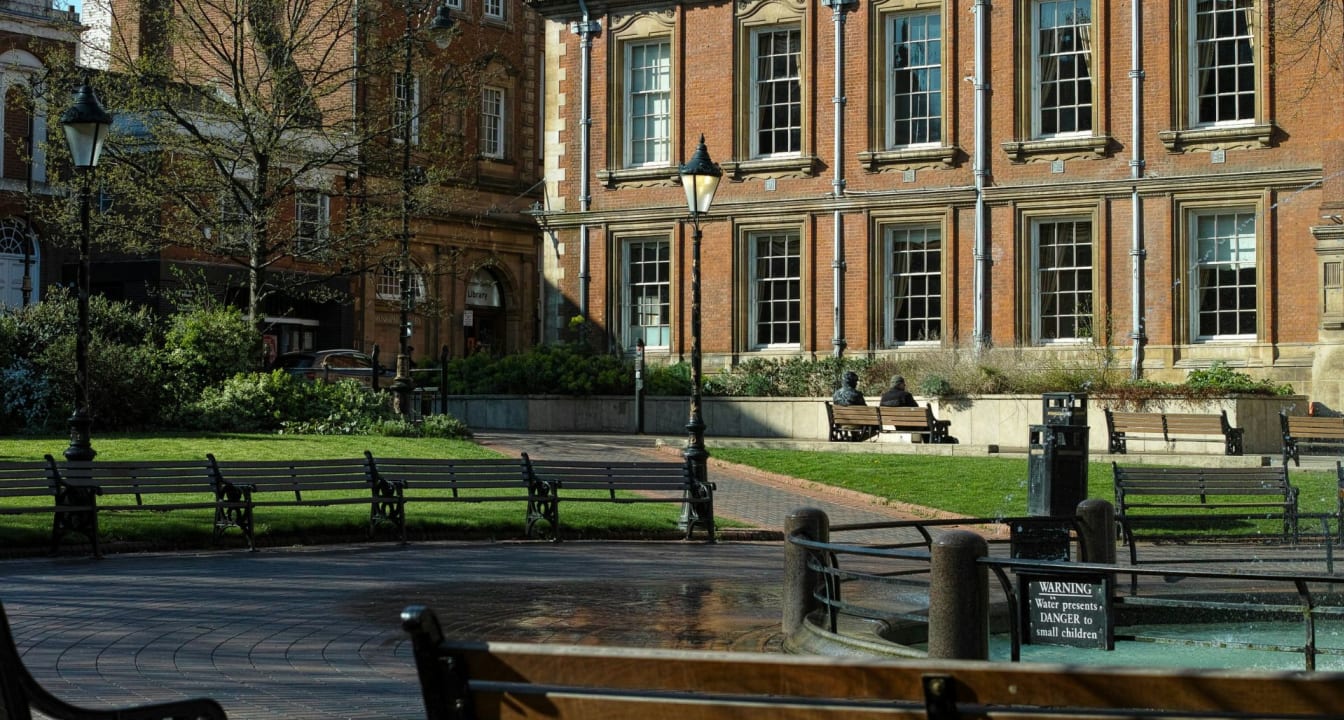 Bench seating outside red brick buildings