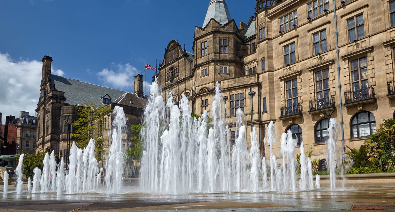 Fountains in Sheffield outside of historic building on a sunny day.