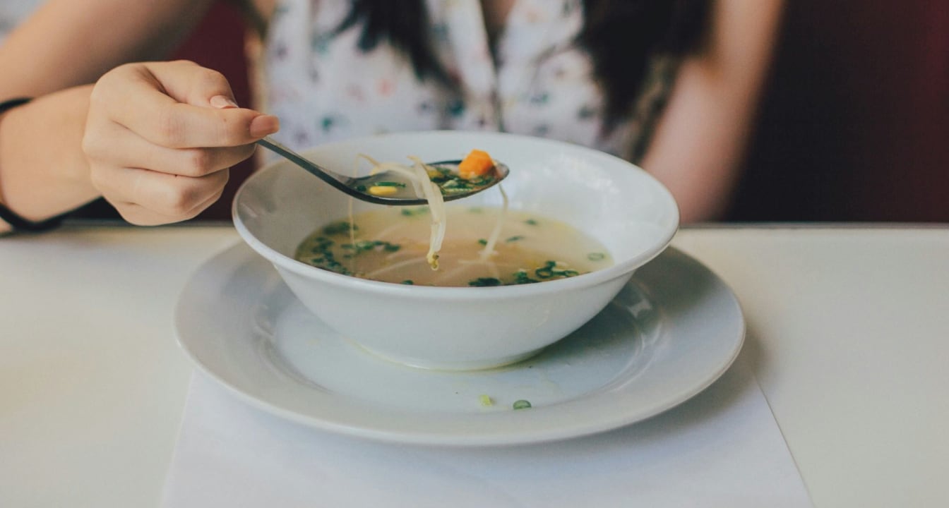 Student eating soup with a spoon