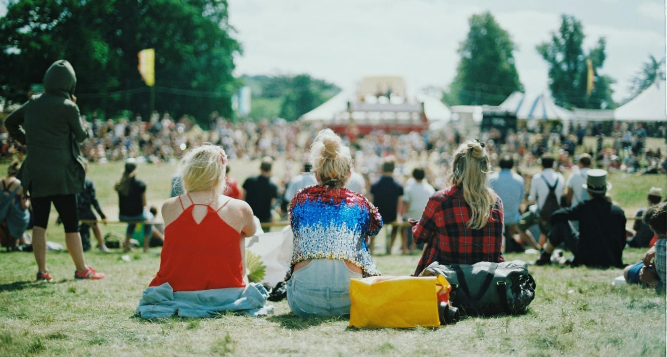 Students sat on the grass at a festival