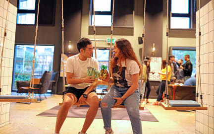 Two students share a drink in a social space at their student accommodation