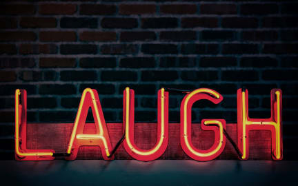 Illuminated sign that says 'Laugh'