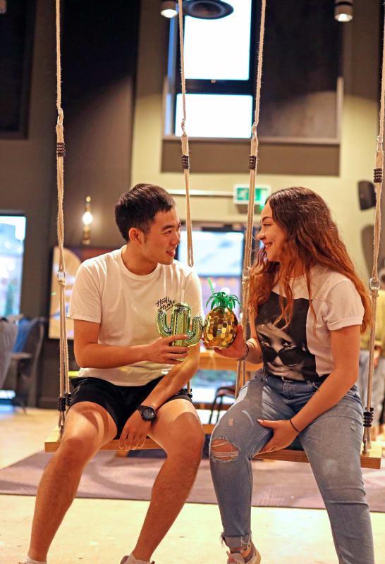 Two students share a drink in a social space at their student accommodation