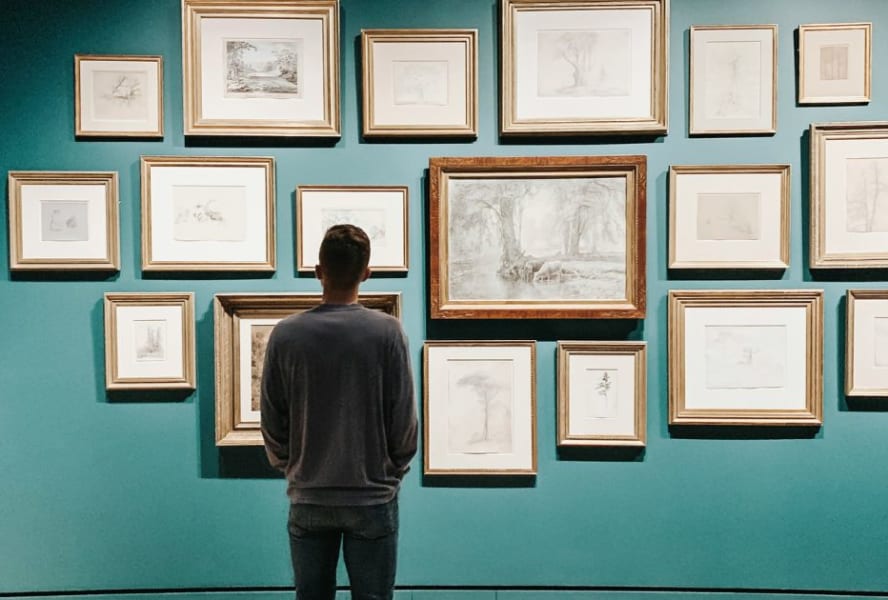 Man stands in art gallery viewing art