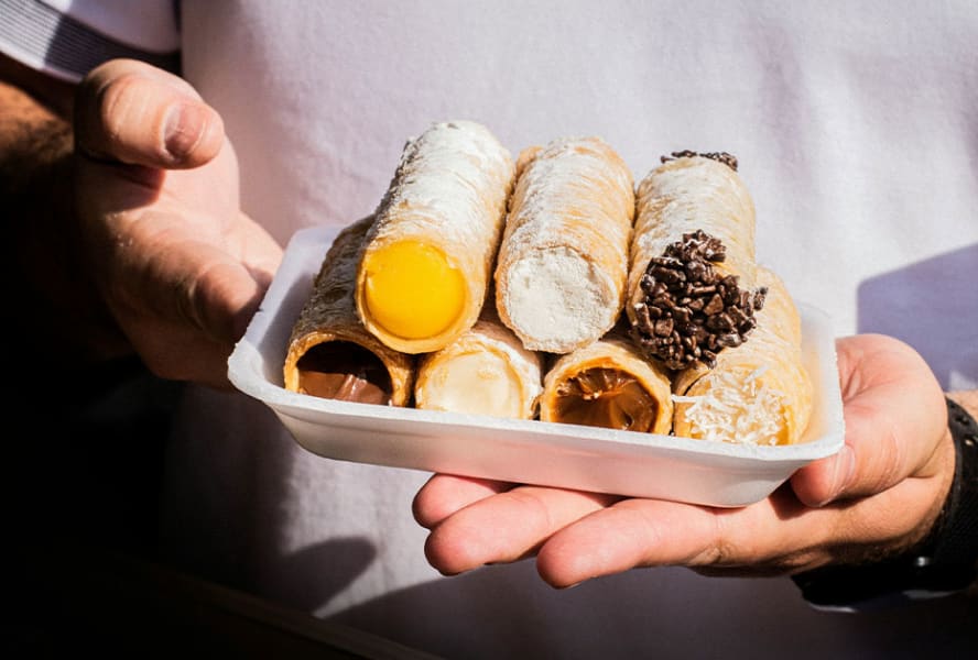 Seven rolls of cannelloni held in a white container