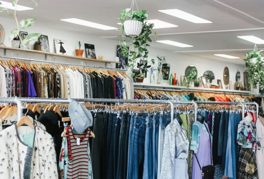 Interior of a charity shop with rails of clothes