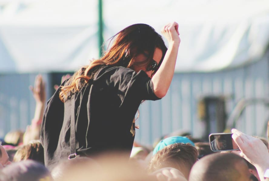 Student dances at a festival, on someone's shoulders