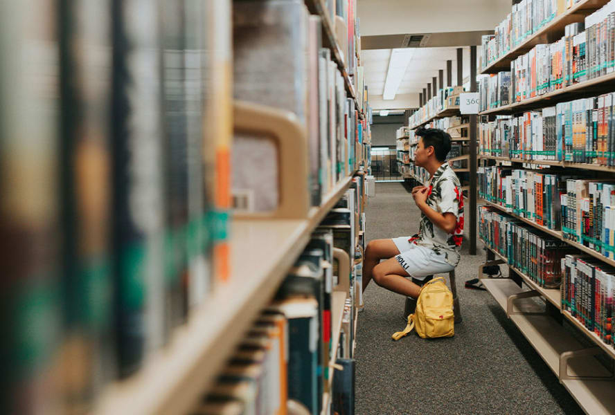 Student in a library sat browsing books.