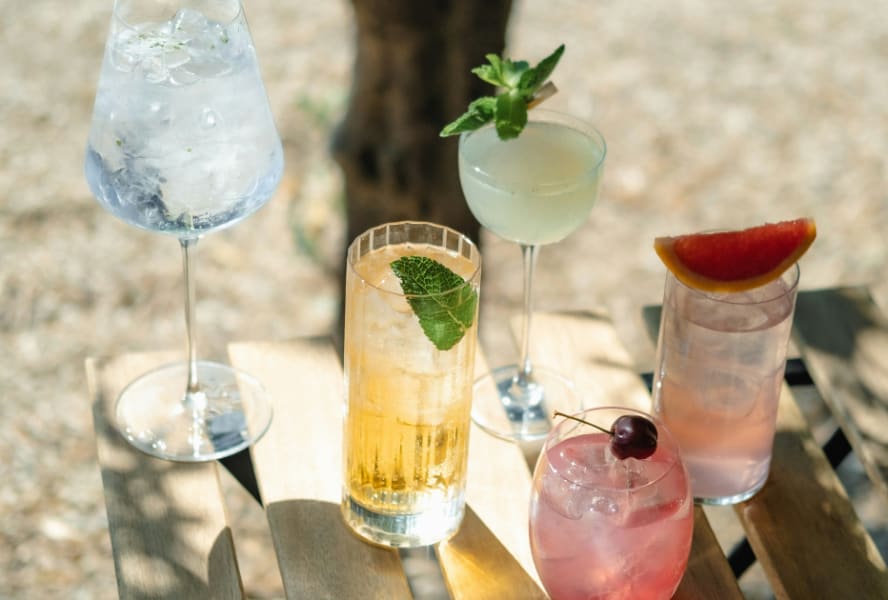 Five mocktails on a table in the sun