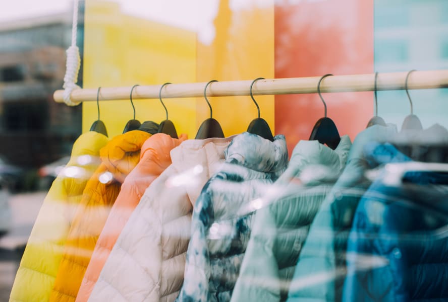 Rainbow-coloured padded coats in a shop window.