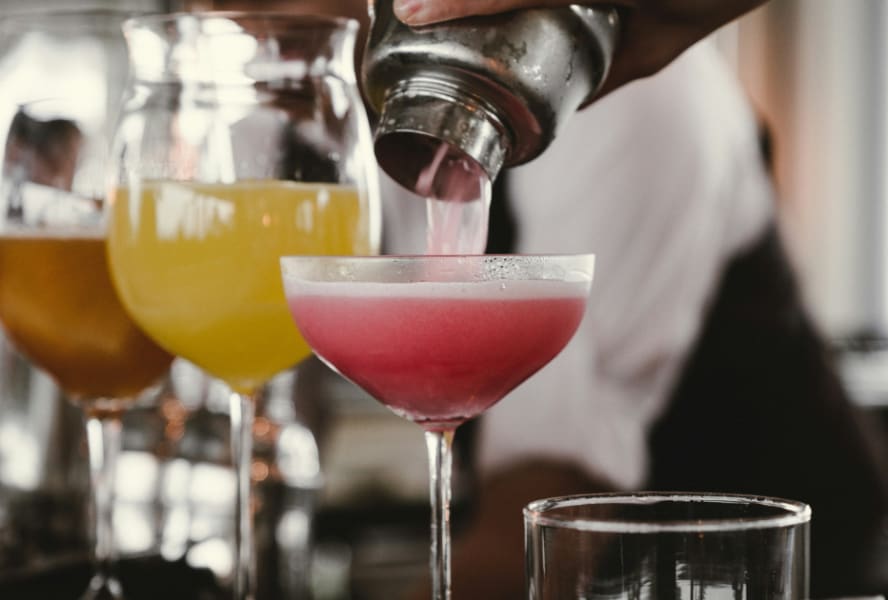 Three mocktails on a bar bring poured from a shaker