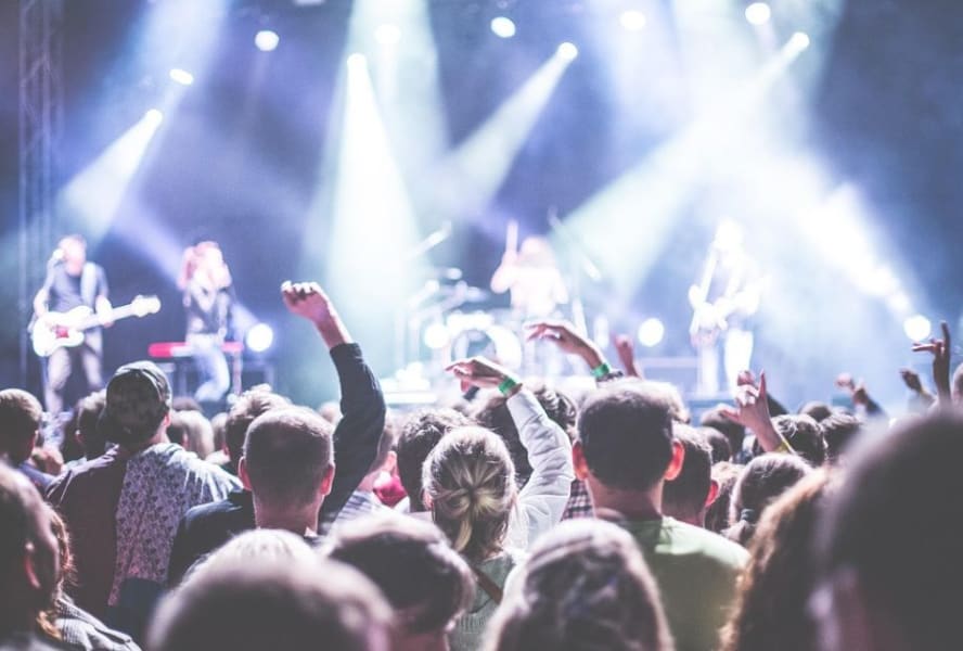 Crowd surrounds a band who perform on stage