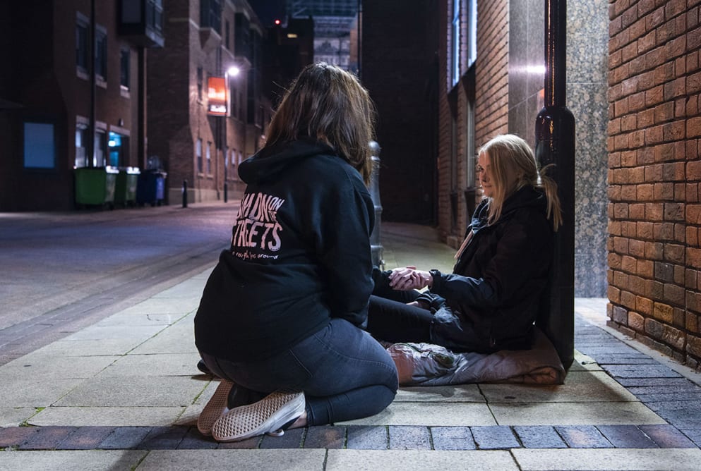 outreach worker and client sat together on the street