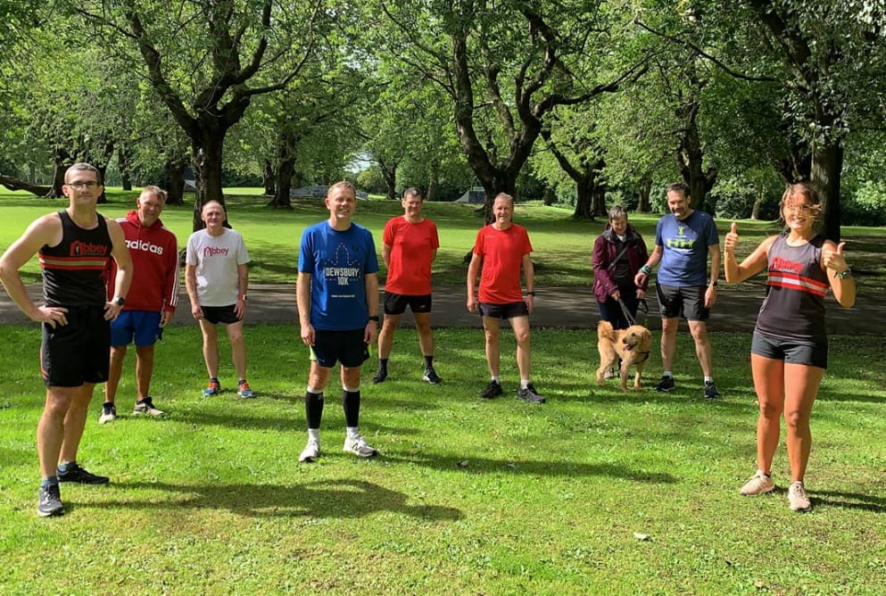 Nine people and a dog standing in Armley Park fundraising money for Simon on the Streets.