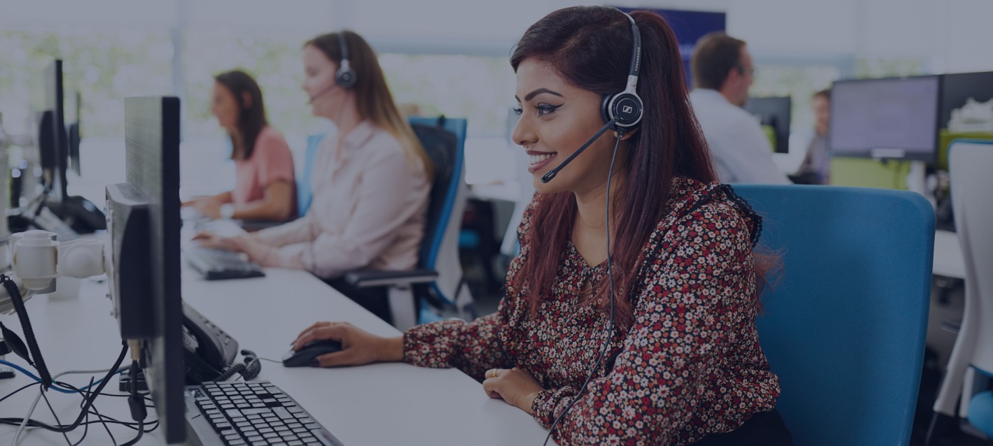 A phone operative speaking on the phone with a customer at her desk in the SmartSearch office