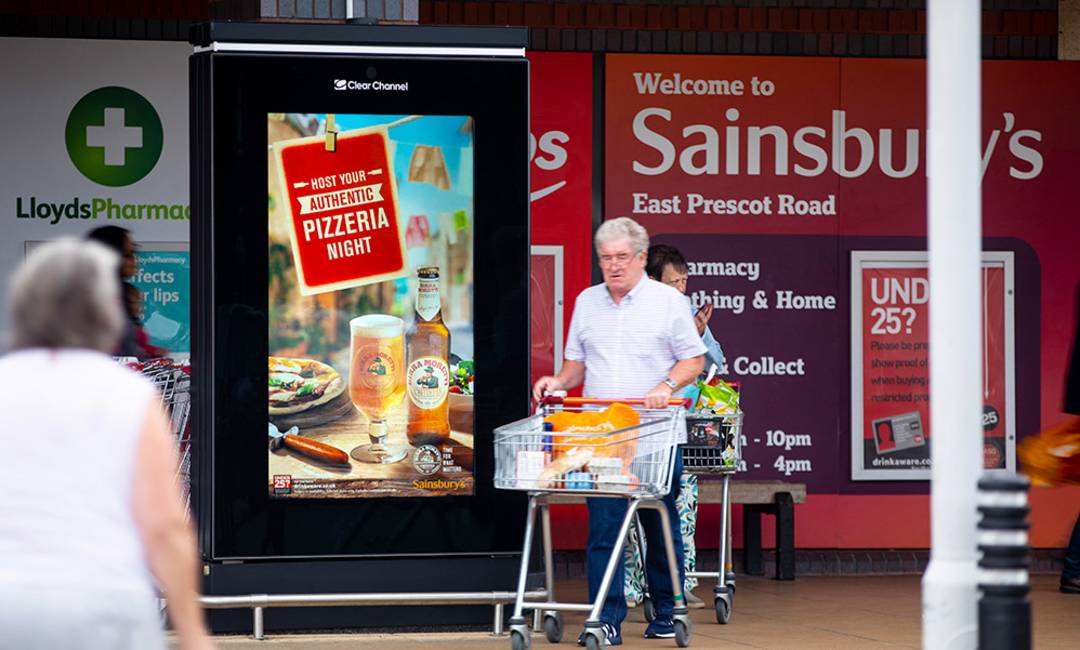 Beer brand advertised outside of a supermarket in summer