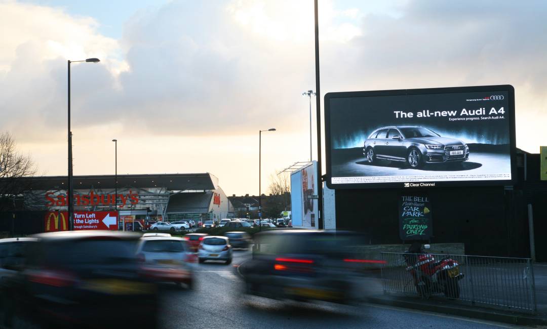 Billboard Live screen showing Audi A4 advert on a busy road