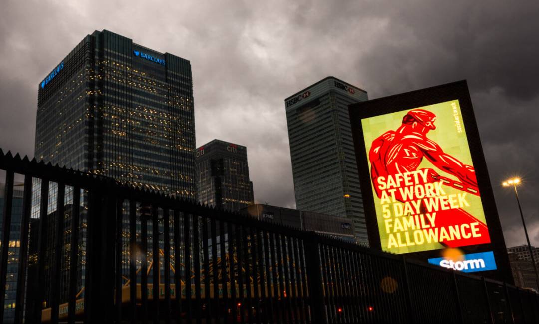 Storm billboard against an overcast sky at Canary Wharf