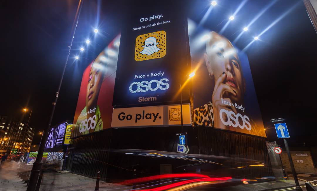 A Storm billboard with a Snapchat advertisement in the middle and two ASOS advertisements on either side displayed at Shoreditch Triangle