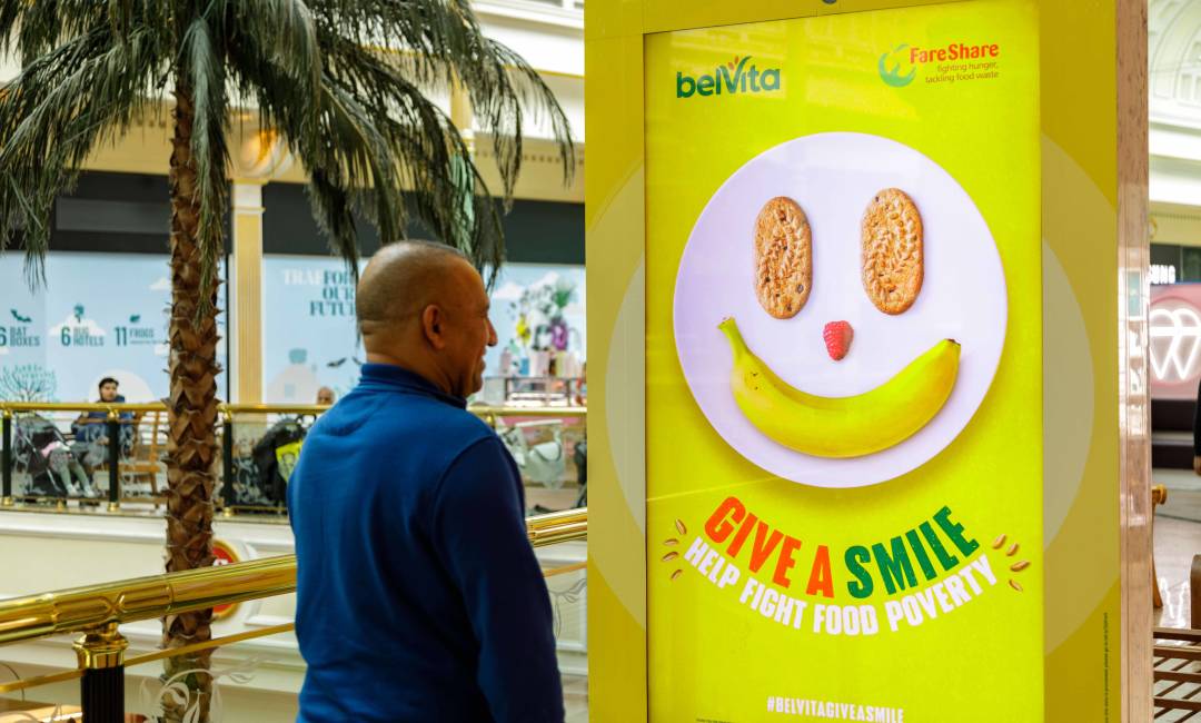 Man smiling at Belvita: Give a smile campaign on Out of Home screen