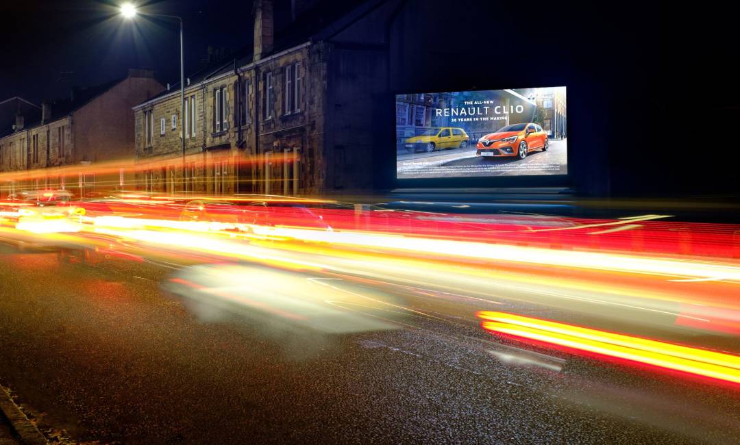 Night time shot of digital billboard advertising screen displaying Renault Clio advert