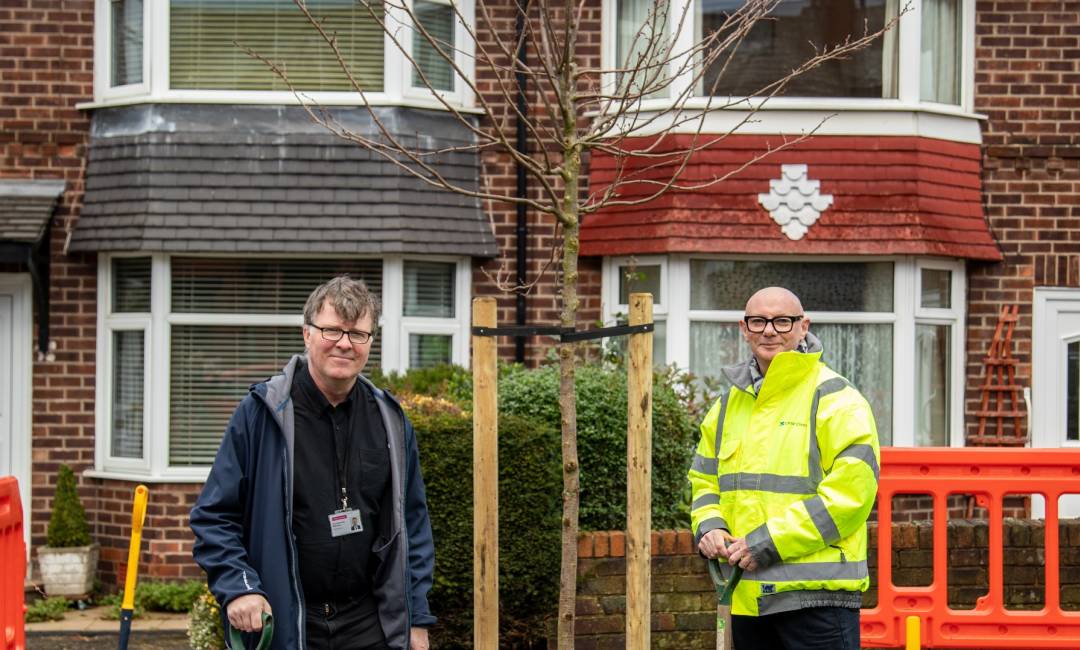 Photo of two people planting a tree in Salford funded by Clear Channel