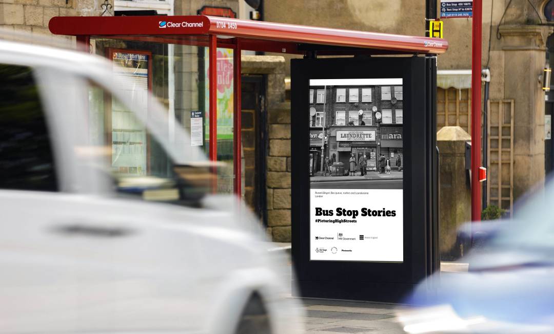 Clear Channel Bus Stop Stories campaign on Adshel Live screen showing a historic photo of a busy high street.