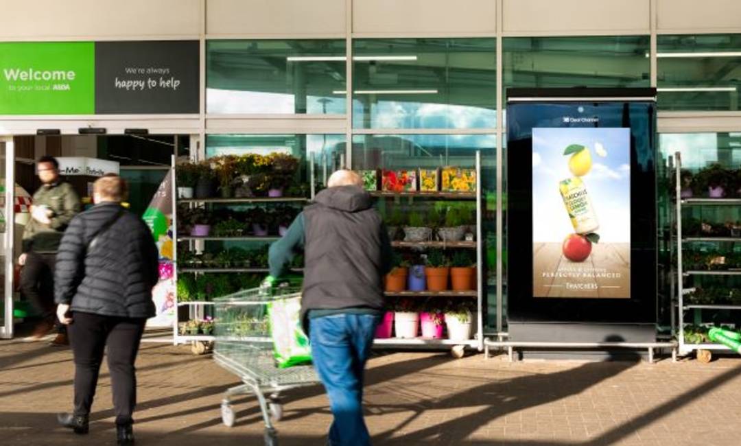 An advertising screen in ASDA supermarket with a Thatchers ad