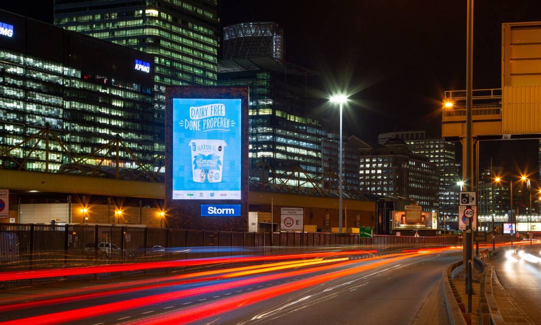 A large Dairy Free blue ad campaign on a Storm screen in London