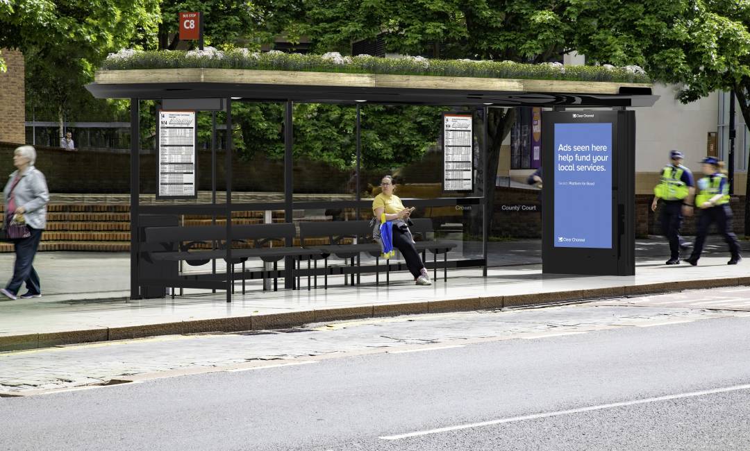 Clear Channel 'Living Roof' bus shelter with blue image on screen with people walking by
