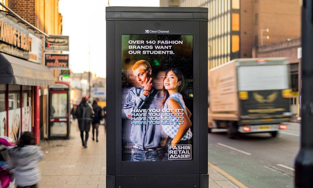 A fashion retail academy advert on a digital roadside panel