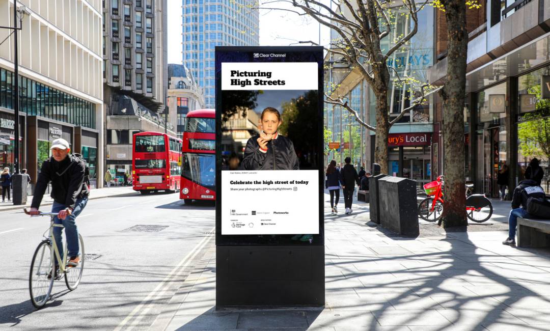 Digital screen on a busy high street showing Clear Channel's Picturing High Streets Campaign