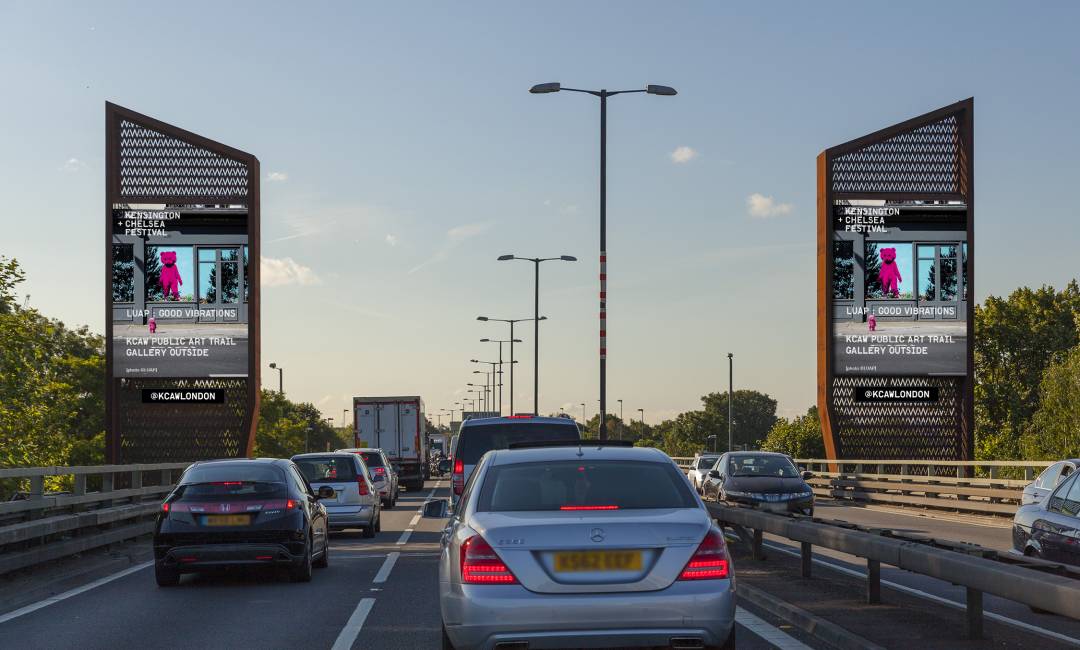 Storm screens on a busy road showing ads for KCAWLONDON