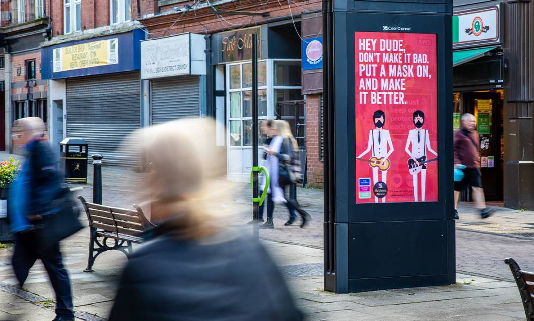 A Covid-19 related campaign on Adshel Live screen on a high street