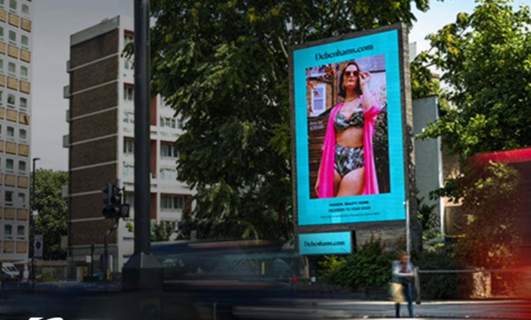 Debenhams.com ad featuring lady in swimwear on large digital screen