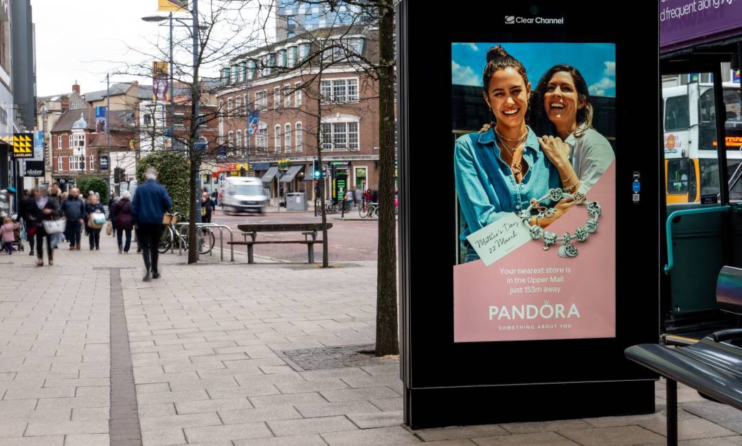 Pandora advert on digital screen on high street with people walking past