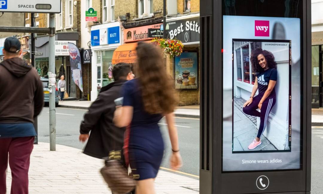 Adshel screen displays 'very' fashion, people walking by