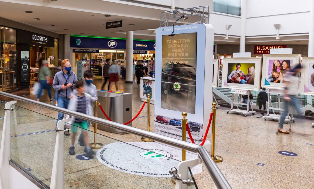 Digital screen in a busy shopping mall near Boots & H Samuel showing Skoda advert